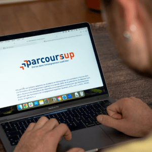 Un homme consulte la plateforme Parcoursup sur son ordianteur.