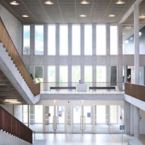 Étudiants en travail déquipe autour dun ordinateur portable dans une salle de classe moderne.