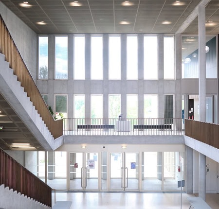 Étudiants en travail déquipe autour dun ordinateur portable dans une salle de classe moderne.