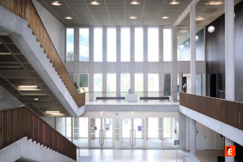 Étudiants en travail déquipe autour dun ordinateur portable dans une salle de classe moderne.