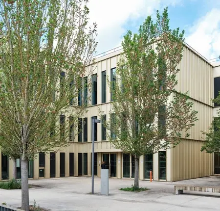 Couloir HEC Paris avec casiers colorés et deux étudiants discutant.