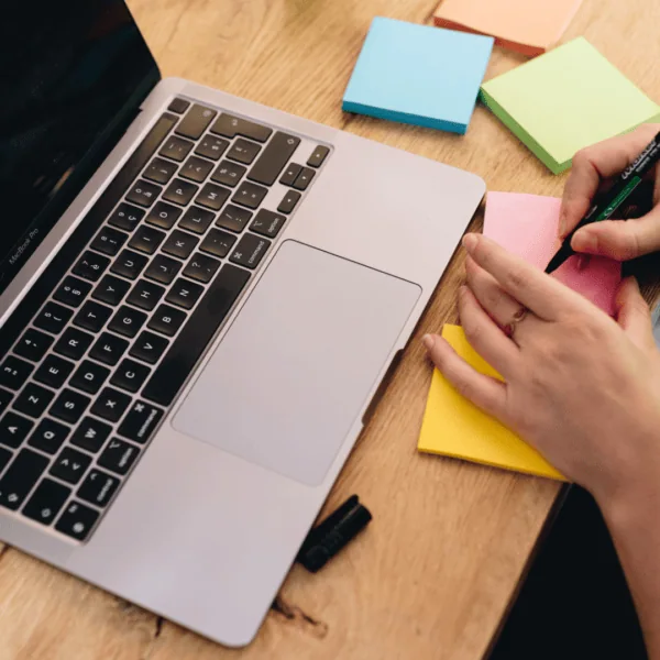 Une personne écrit sur des post it de couleur.