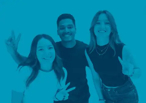 Portrait de groupe de trois jeunes souriants en teinte cyan, fond uni.