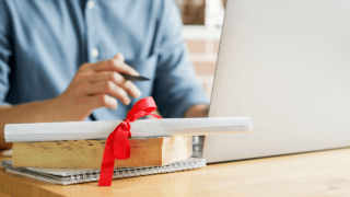 Un diplôme posé devant un ordinateur.