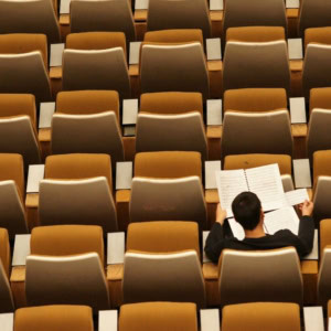 Un étudiant seul dans un amphi.