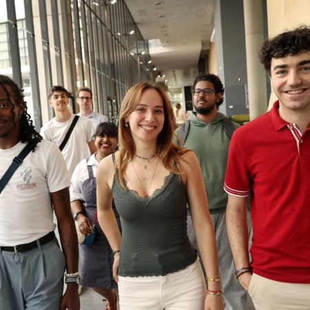Un groupe d'étudiants souriants dans les couloirs de CY Cergy Paris