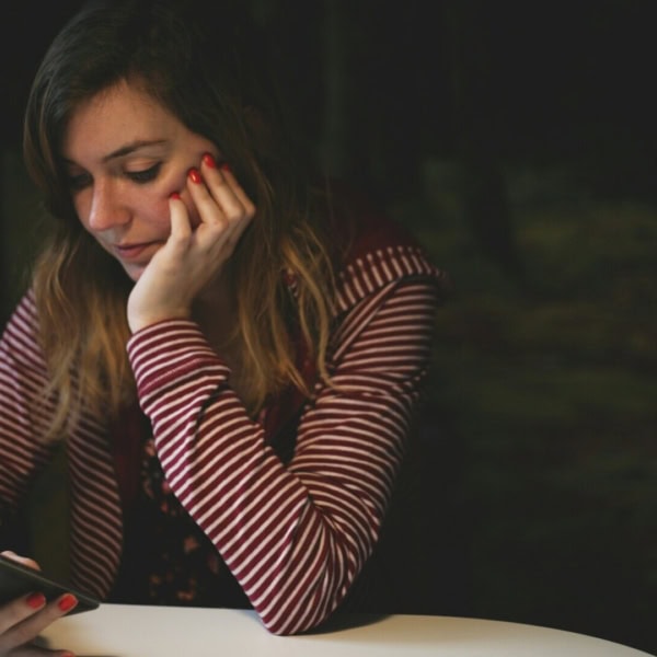 fille qui réfléchie sur son téléphone