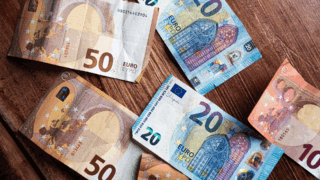 Des billets de 20 et 50 euros éparpillés sur une table.