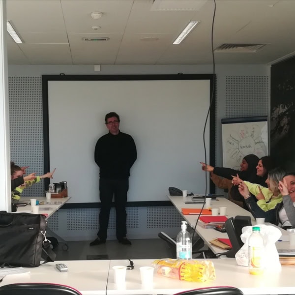 plusieurs personnes assises autour d'une table de classe