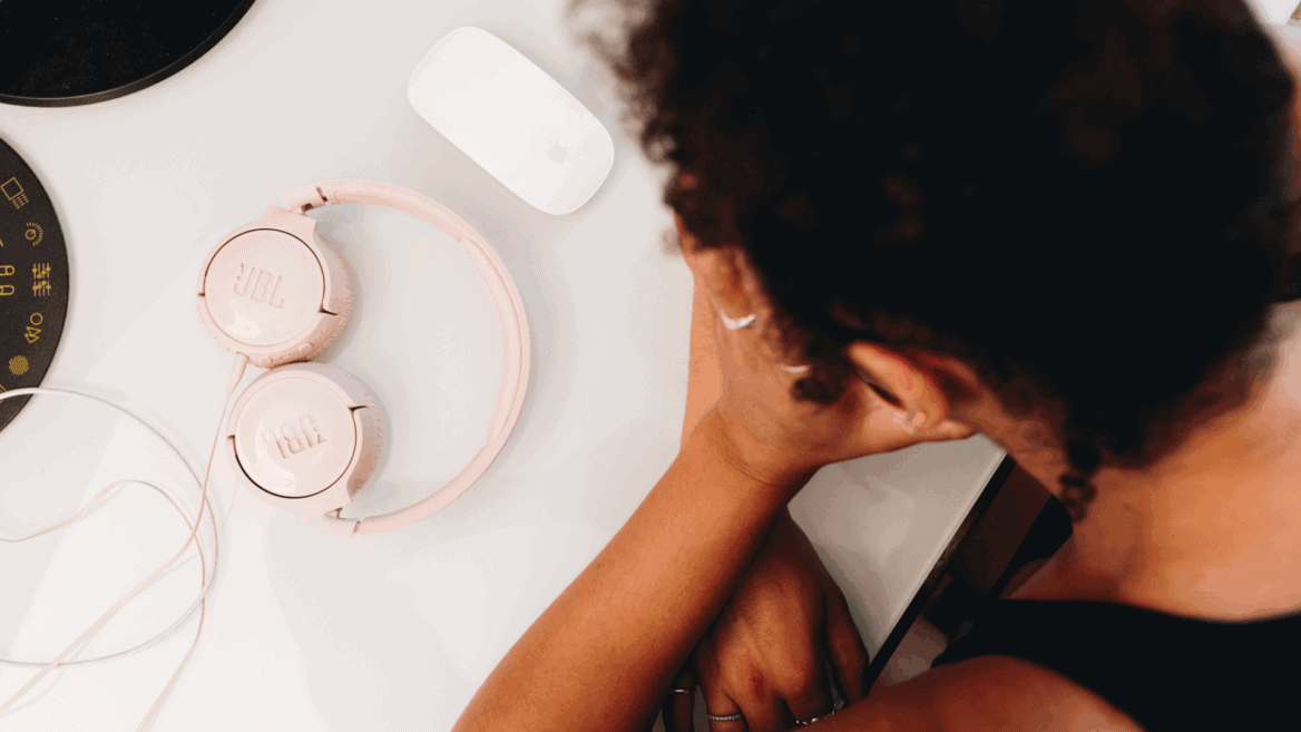 Une jeune femme tient sa tête dans ses mains.