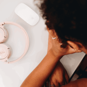Une jeune femme tient sa tête dans ses mains.