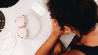 Une jeune femme tient sa tête dans ses mains.