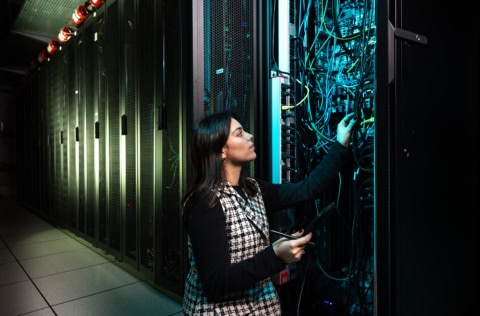 Une étudiante posant devant des câbles pour illustrer une vidéo