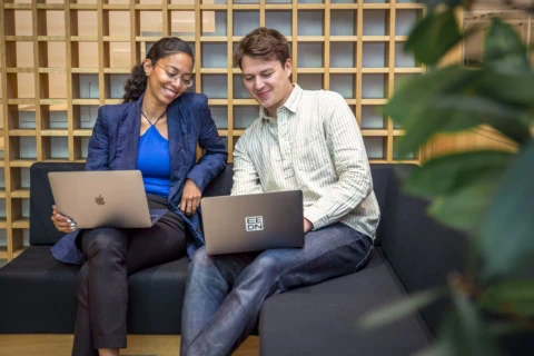 Étudiants assis dans un canapé avec un ordinateur