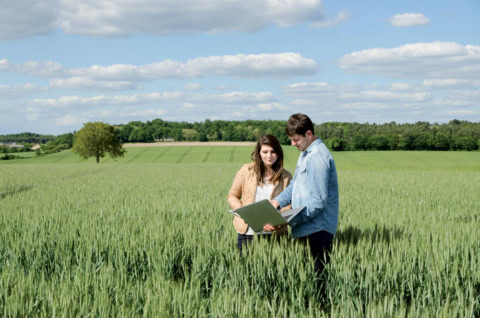 Vue de 2 jeunes étudiants ordinateur dans les mains dans un champ pour illustrer Licence pro MEA