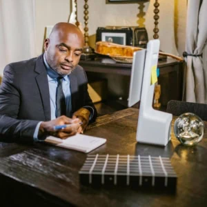 Personne d'environ 40 ans qui prend des notes