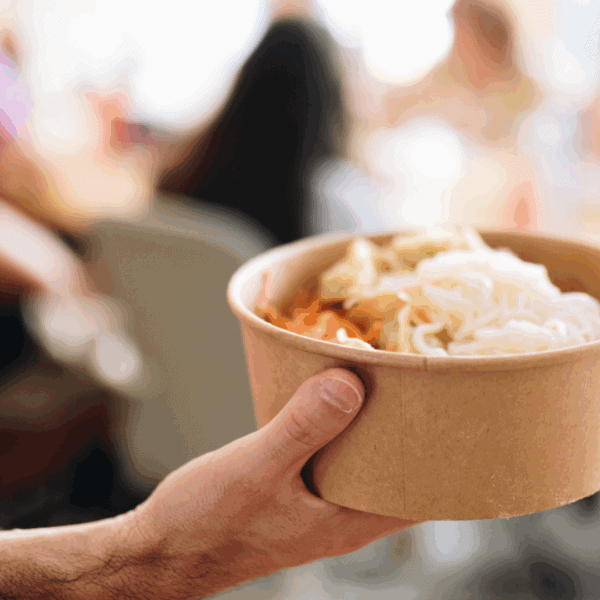 Une personne tient dans sa main un plat à emporter.