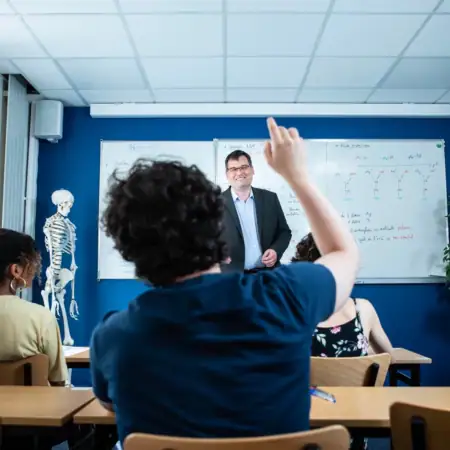 Un prof debout dans une salle de groupe entrain d'enseigner
