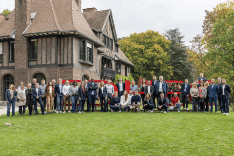 Une équipe de personnes posant sur une pelouse dans les locaux de l'EDEHC