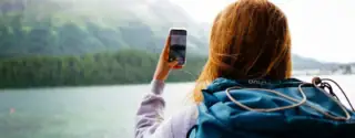 Une femme tenant son téléphone dans les mains face aux montages