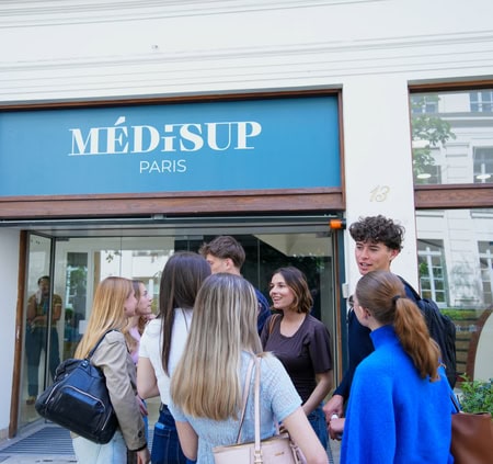 Étudiants devant lentrée Médisup Paris, groupe en discussion près des portes vitrées.