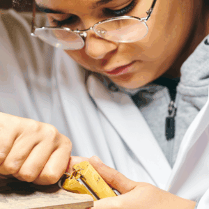 Un jeune réalise une pièce de joaillerie.