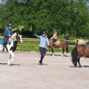 Un professeur d'équitation donne cours à ses élèves.