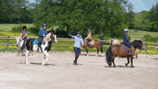 Un professeur d'équitation donne cours à ses élèves.