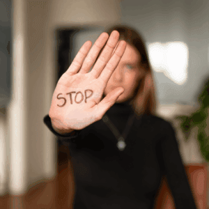 Une femme tend la main sur laquelle il est écrit Stop.