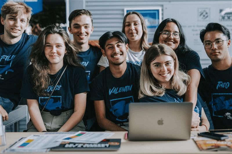 Un groupe d'étudiants souriant illustrant le Bachelor in Management