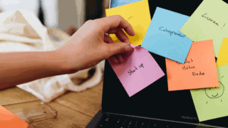 Une main décroche un post it start up, entrepreneuriat.