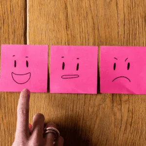 Un smiley content sur un postit rose.