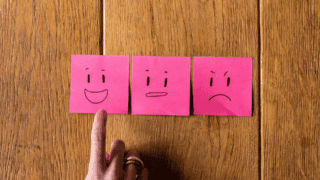 Un smiley content sur un postit rose.