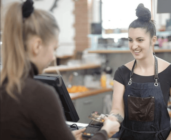 2 femmes vue de près dont une entrain de payer à la caisse