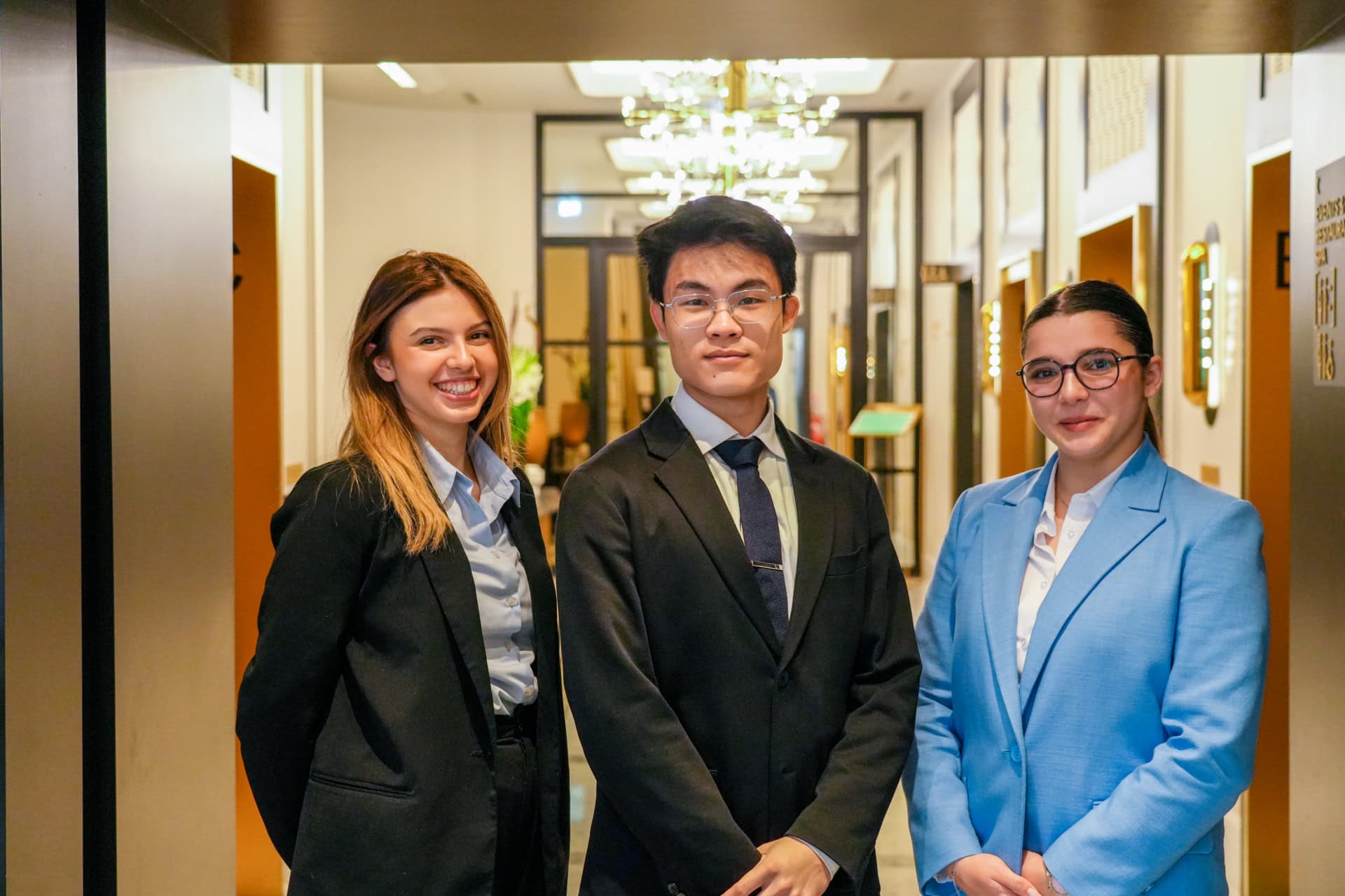 3 étudiants posant dans un couloir