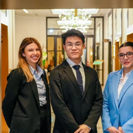 3 étudiants posant dans un couloir