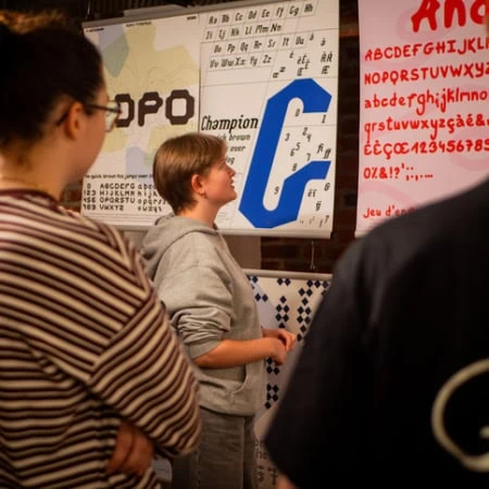 enseignante discutant avec une étudiante assise sur un bureau