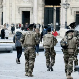 Quatre militaires patrouillent dans la rue.