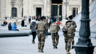 Quatre militaires patrouillent dans la rue.