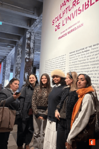 Un groupe d'étudiantes devant une grande affiche