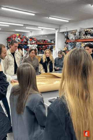 Un groupe d'étudiants debout dans un atelier de couture