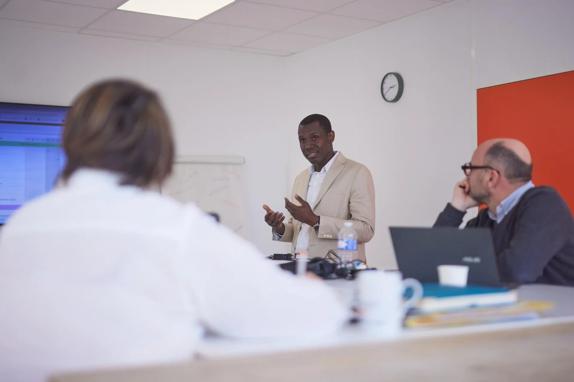 Un homme debout entrain de faire une présentation en salle de réunion