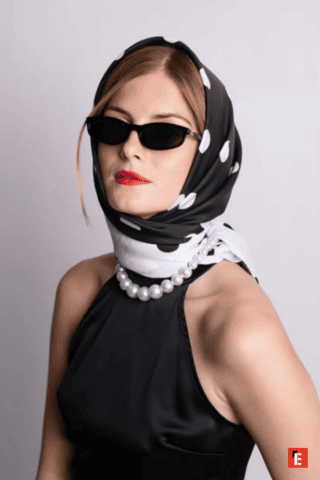 Une femme portant un foulard à pois avec des lunettes de soleil