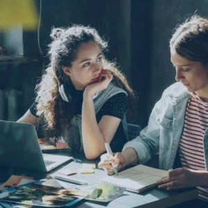 femmes sur un bureau avec leur ordinateur et cahier