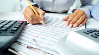 femme-qui-écrit-et-calculatrice