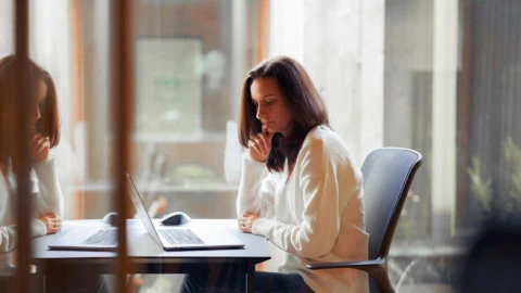 femme qui travaille sur ordinateur assise à son bureau