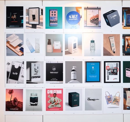 Mur portfolio demballages et maquettes packaging pour identité visuelle studio créatif.