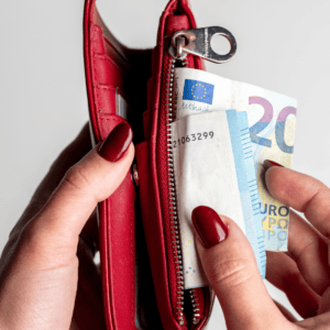Une personne retire un billet de 20 euros de son porte-monnaie.
