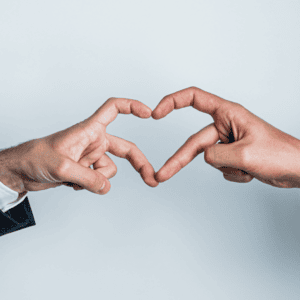 Deux hommes forment un coeur avec leurs mains.