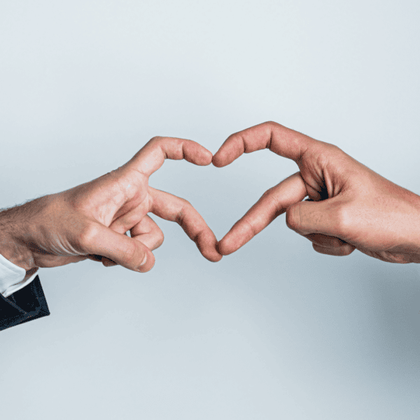 Deux hommes forment un coeur avec leurs mains.